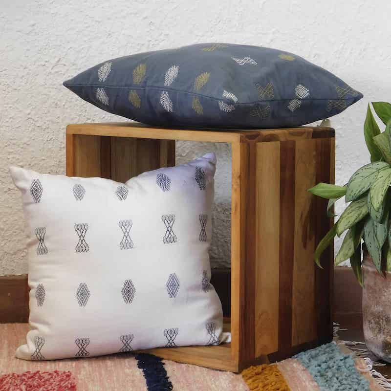 cojines grises y blancos tejidos y bordados