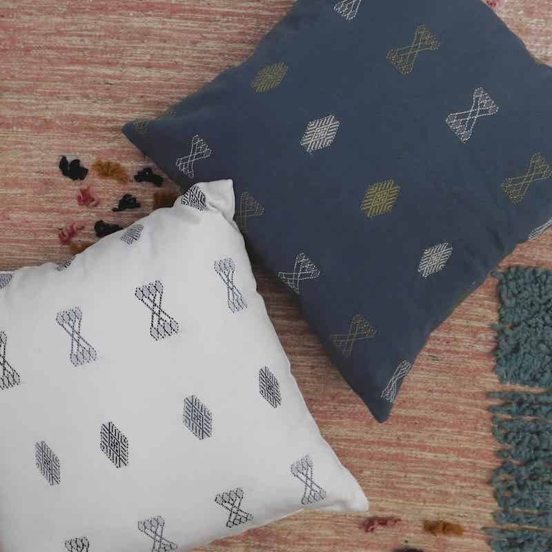 cojin artesanal tejido y bordado en gris y blanco