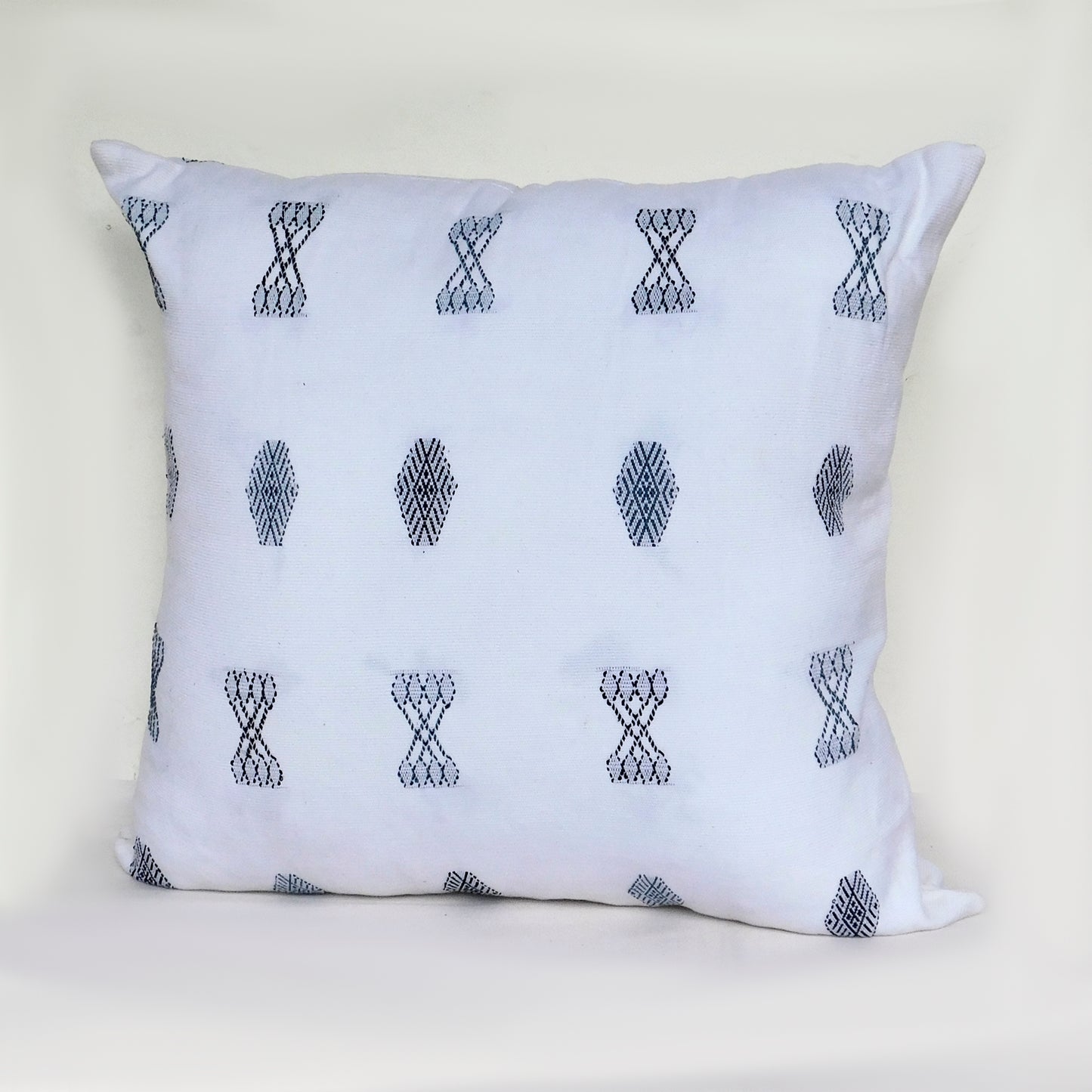 Cojines blancos y grises de la colección Cucanjá