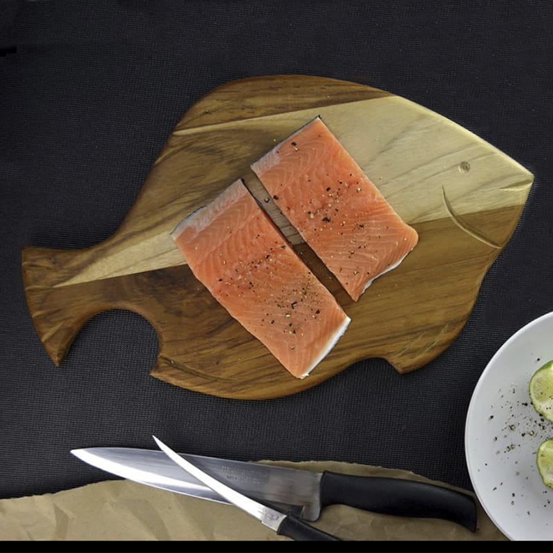 tabla de madera teca para cortar en forma  de pescado con filetes de pescado encima