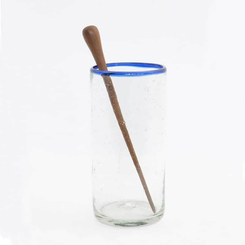 agitador de madera en forma de gota dentro de un vaso de cristal