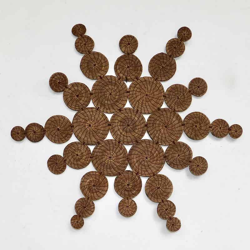 sol decorativo hecho con agujas de pino secas