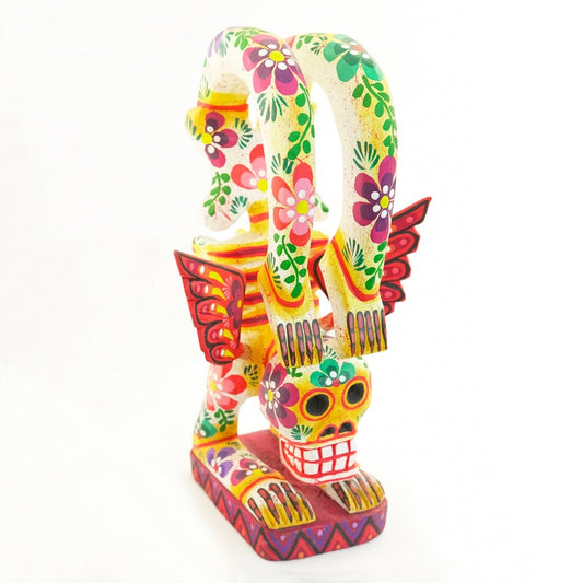 Esqueleto decorativo tallado con las manos en el suelo y los pies levantados sobre su cabeza pintado con flores de colores