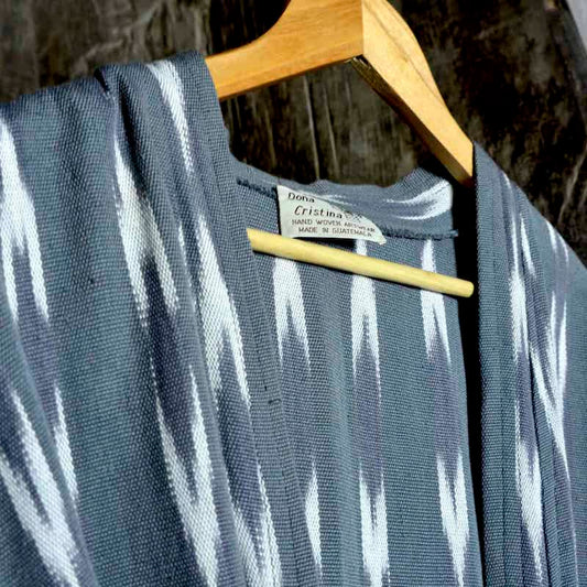 bata gris con franjas blancas colgada de una cercha de madera