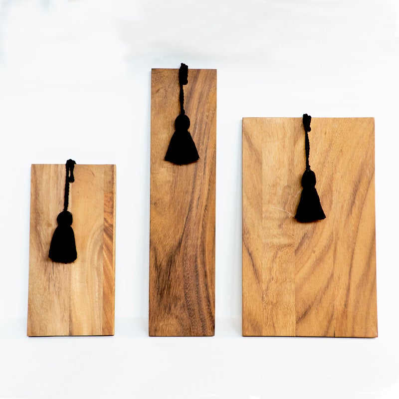 tres tamaños de tablas de madera con borlas de hilo negro en un extremo