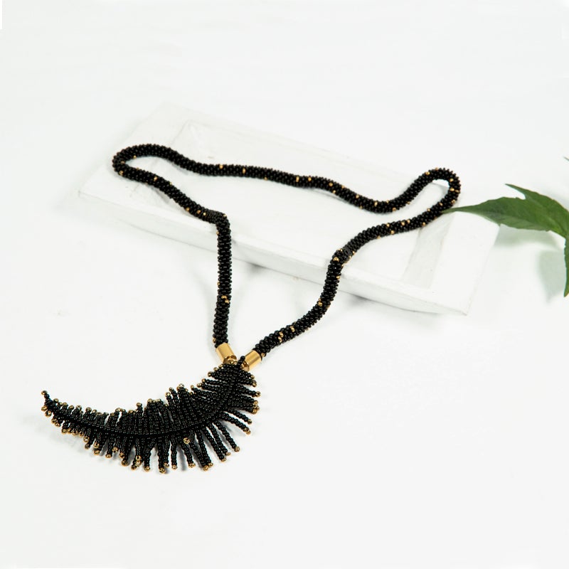 Collar negro y dorado  diseño de pluma hecho con mostacillas por artesanas Guatemaltecas.