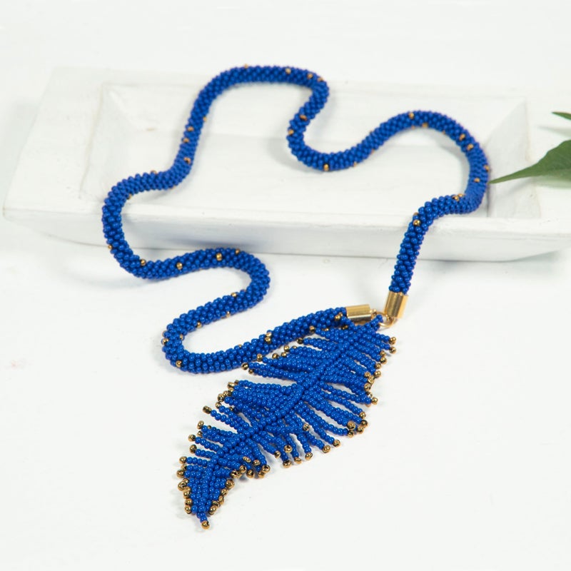 collar con una pluma hecha con mostacillas color azul y dorado 