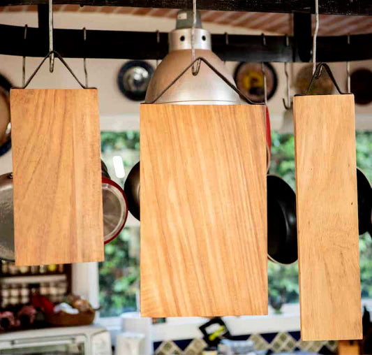 tres tablas de madera con asas de cuero colgadas de ganchos de metal
