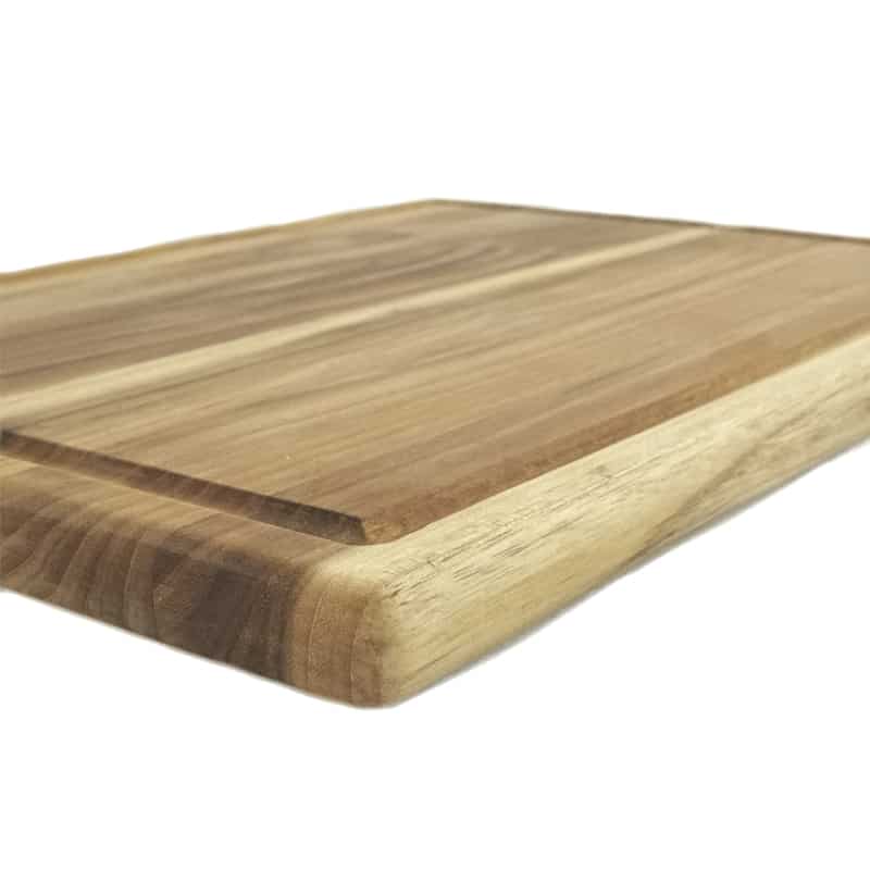 side view of a teak cutting board with juice groove