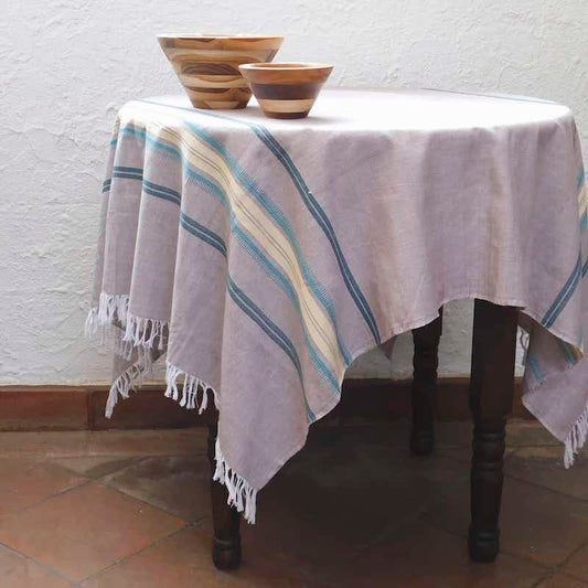 mantel color gris arena con franjas verdes, turquesa y crema