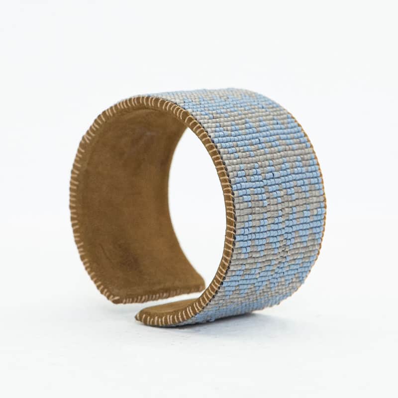 pulsera ancha rígida con patron geométrico hecha con mostacillas y forro de cuero café